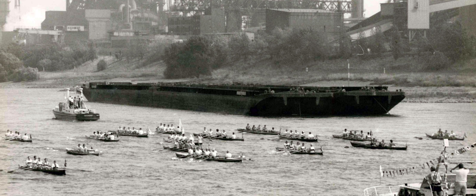 Schwarz-weiß Foto mit Ruderern auf dem Rhein.
