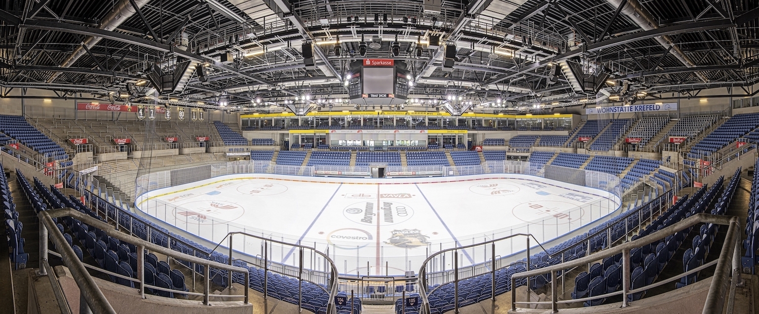 Ein leeres Eishockey-Stadion mit blauen Sesseln von innen mit einem Fisheye-Objektiv aufgenommen.