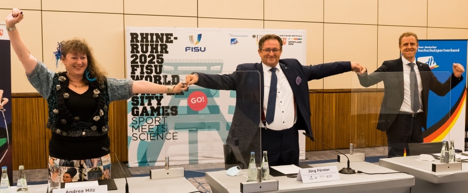 Andrea Milz und Jörg Förster stehen jubelnd nebeneinander während einer Pressekonferenz.