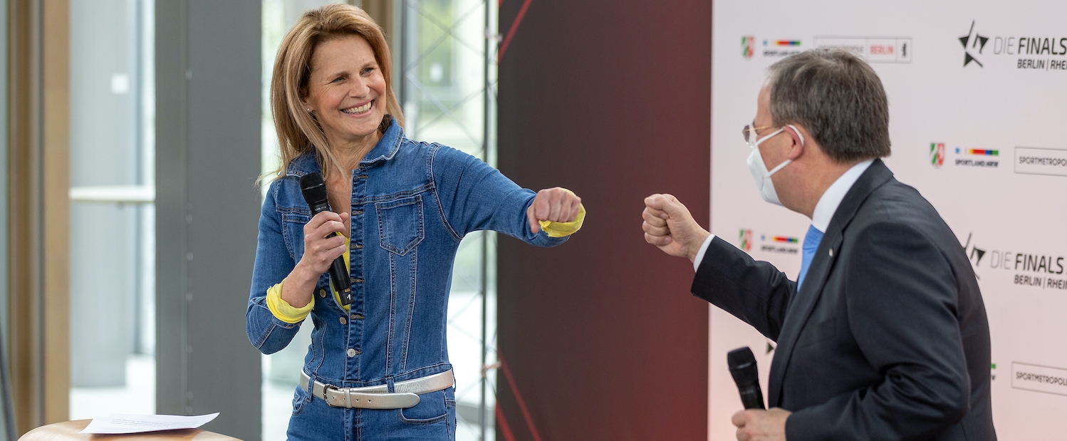 Armin Laschet begrüßt Moderatorin Katrin Müller-Hohenstein mit einem Faustschlag