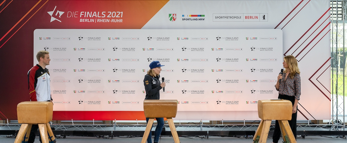 Pressekonferenz mit Sportlern. Im Hintergrund ist die Pressetafel mit der Aufschrift Sportland NRW und Die FInals 2021