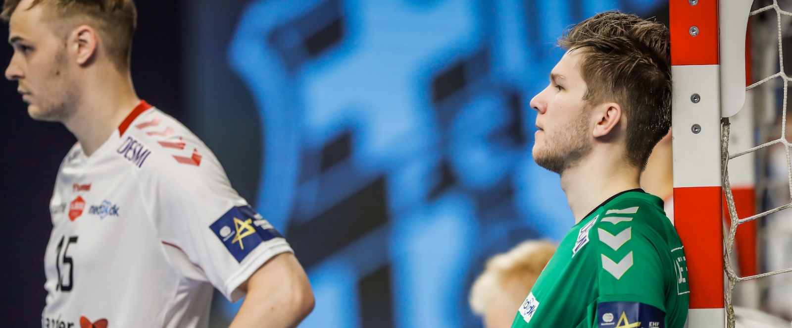 Zwei Handball-Spieler, einer lehnt an den Pfosten