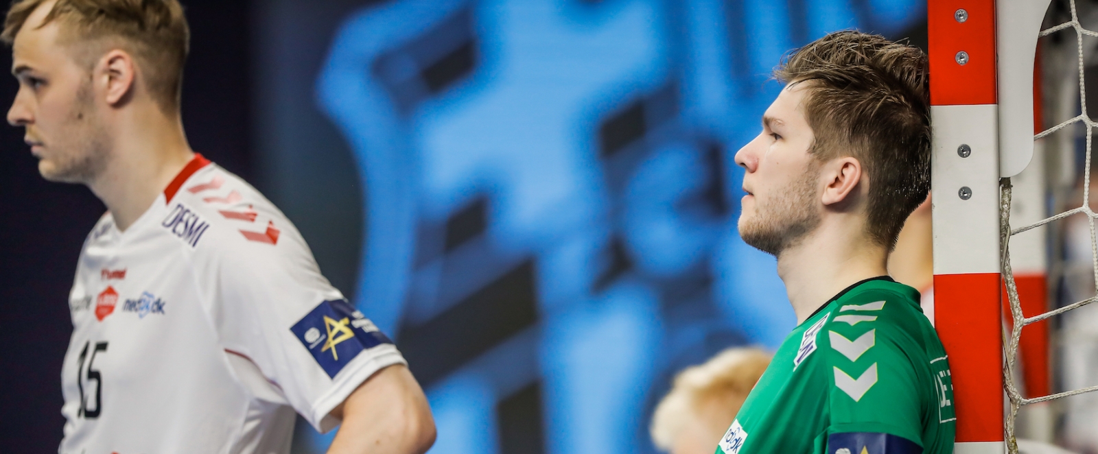 Handball Torhüter steht traurig am Torpfosten