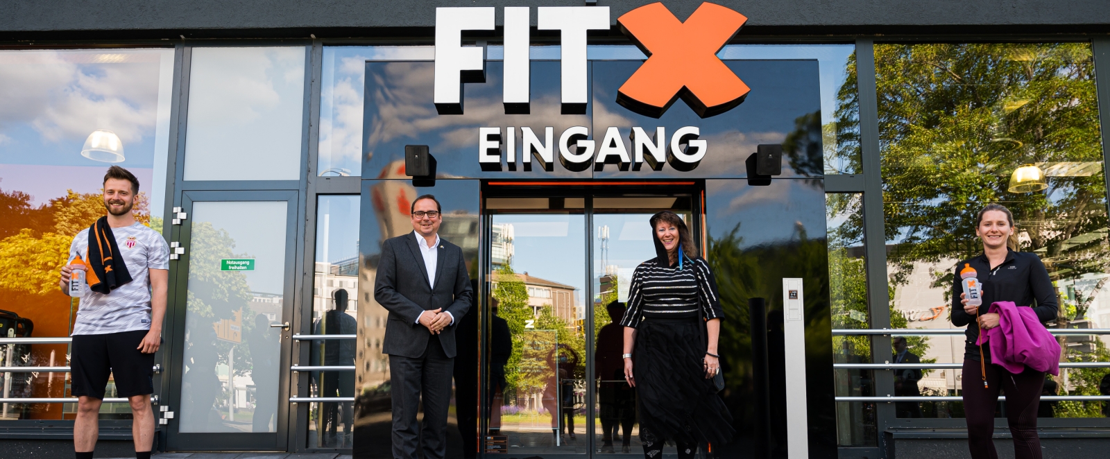Staatssekretärin Milz vor einem Fitness-Studio-Eingang.