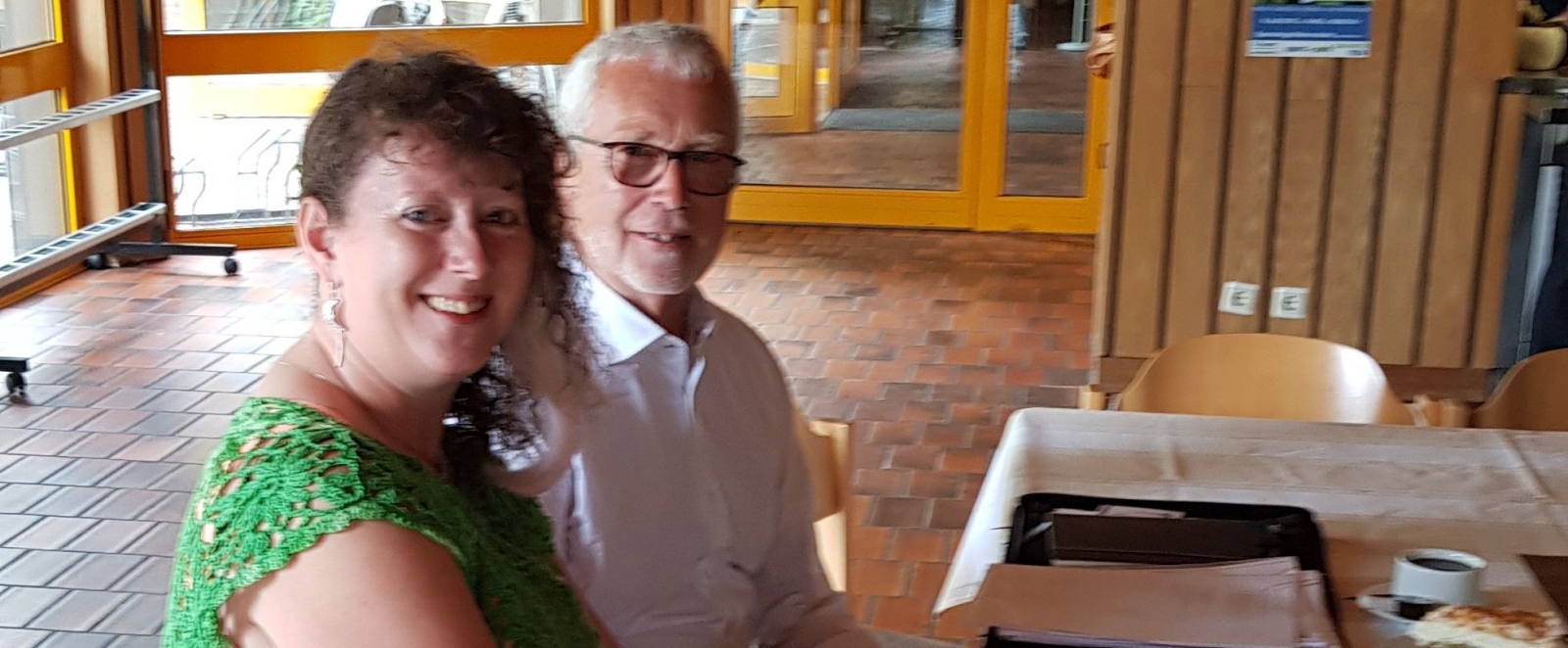 Staatssekretärin Andrea Milz sitzt mit dem Vorsitzendem Wolfgang Rombey an einem Tisch in den neuen Geschäftsräumen.