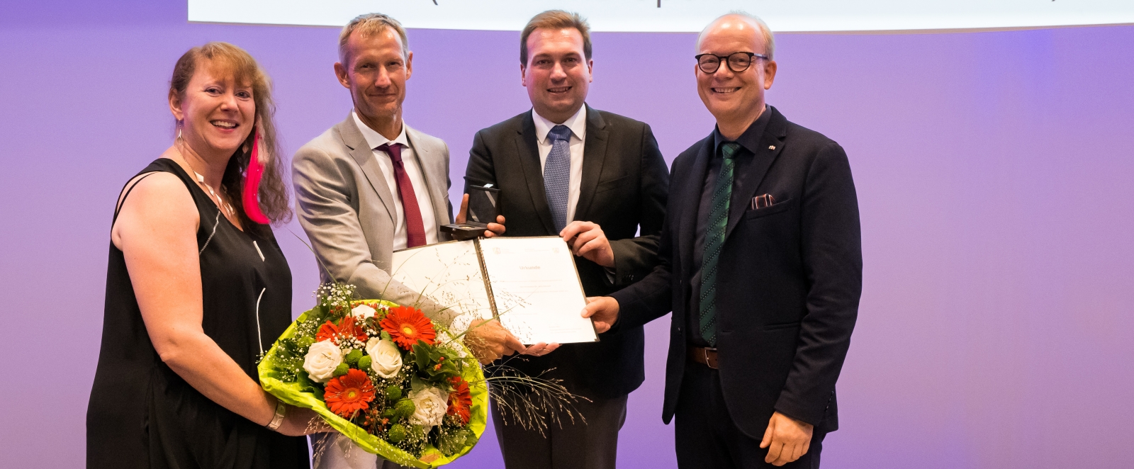 Staatssekretärin Milz überreicht einen Blumenstrauß an den Preisträger Prof. Dr. Jens Kleinert.