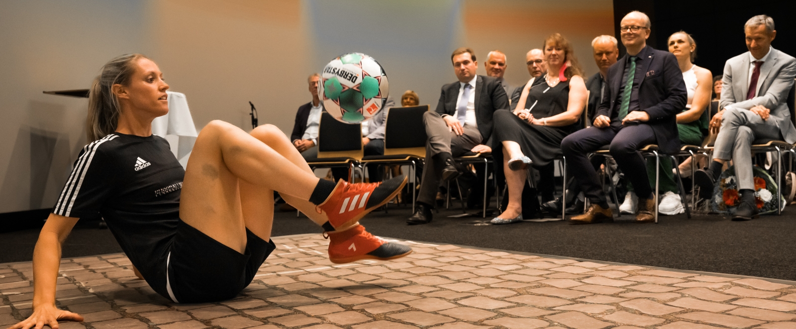 Eine Fußballartistin bei einer Showeinlage mit Ball am Fuß.