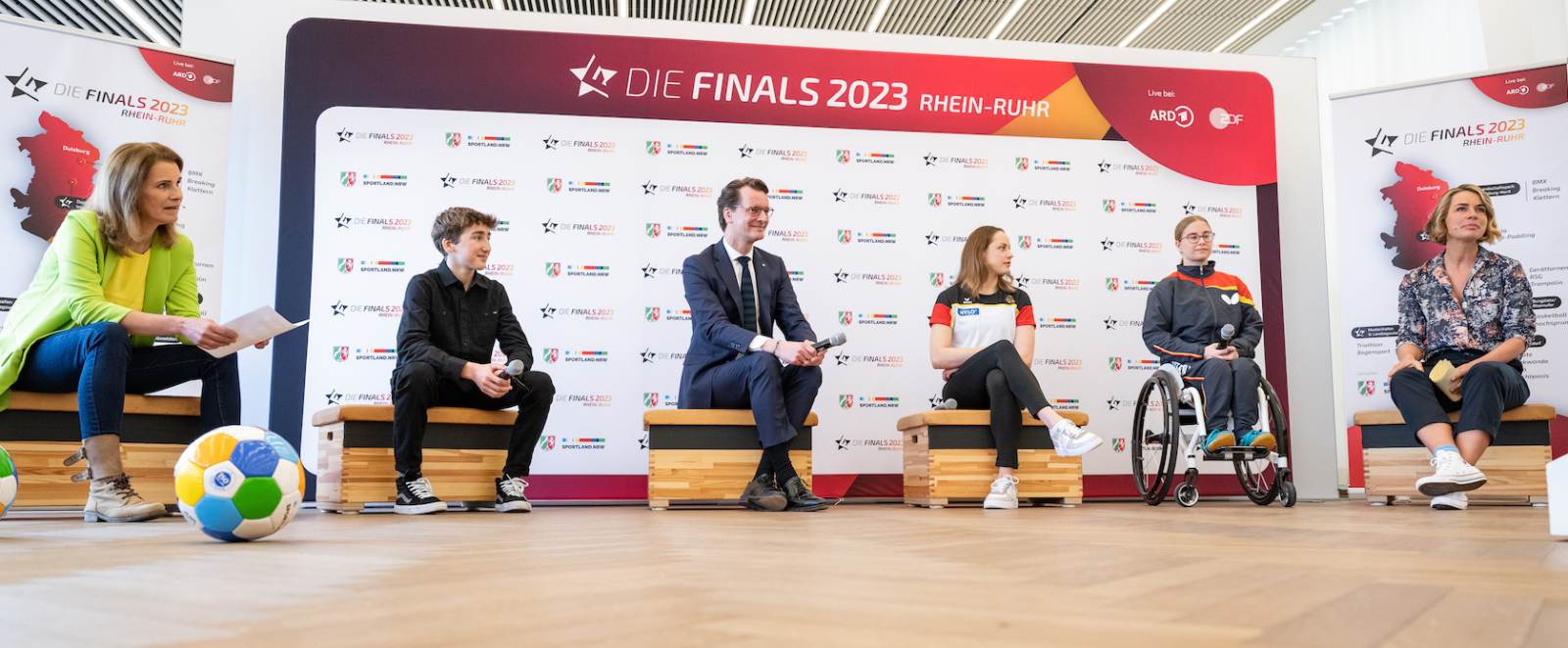 Pressegespräch bei einer Pressekonferenz vor Sponsorenwand