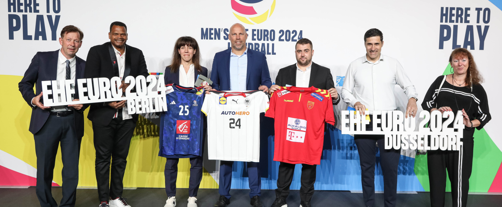 Gruppe Menschen vor Sponsorenwand der EHF EURO 2024