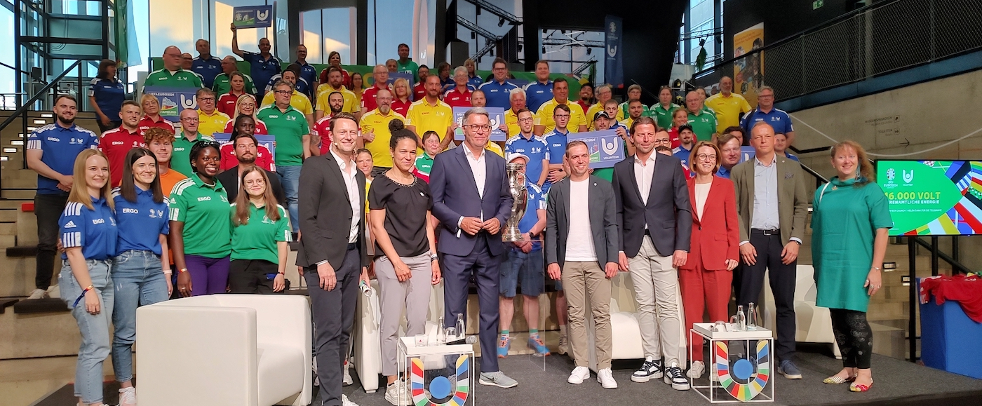 Podium mit vielen Personen zum Launch des Volunteer Programms