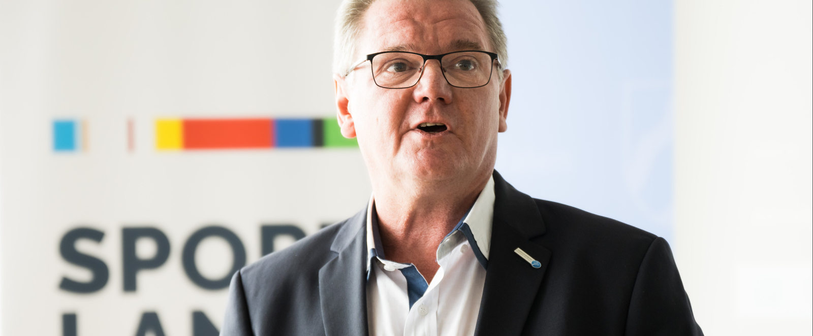 Gerhard Stiens vor Banner des Sportland.NRW