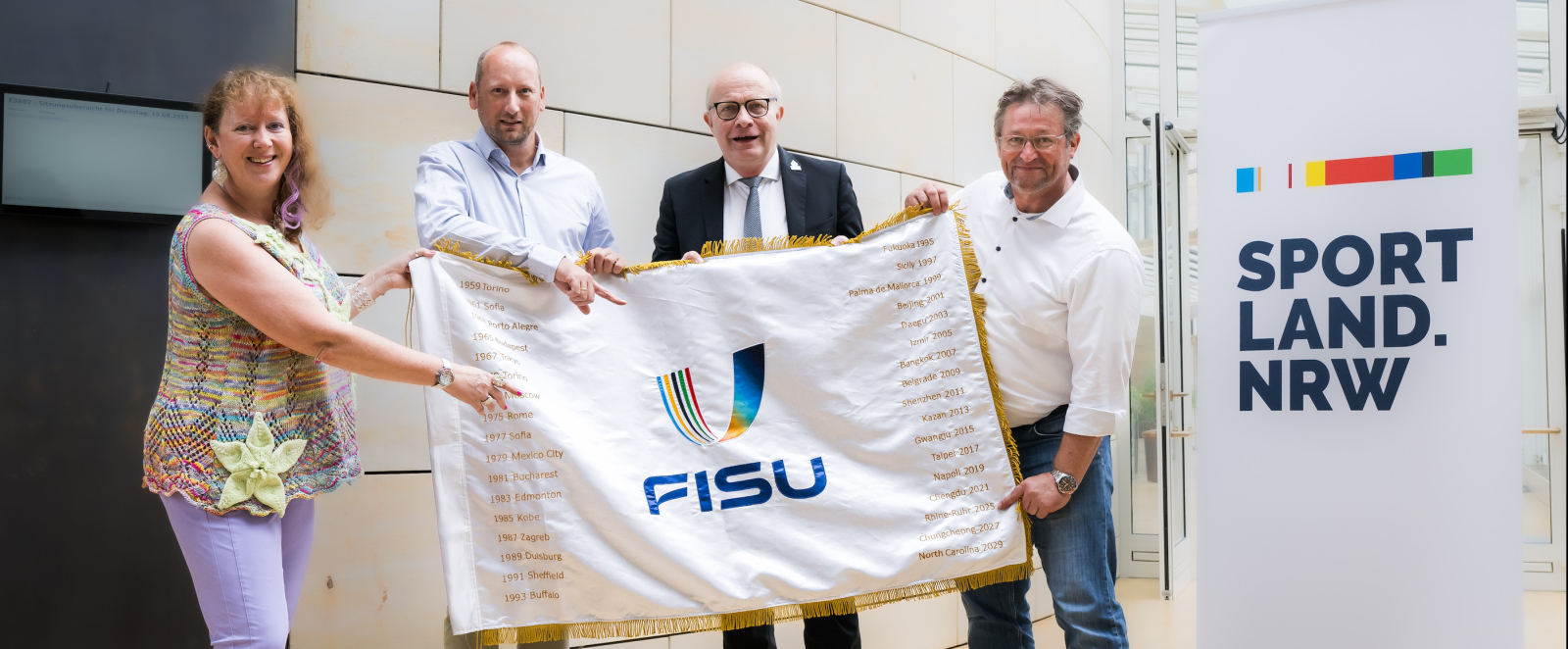 Andrea Milz und weitere Personen mit FISU-Flagge