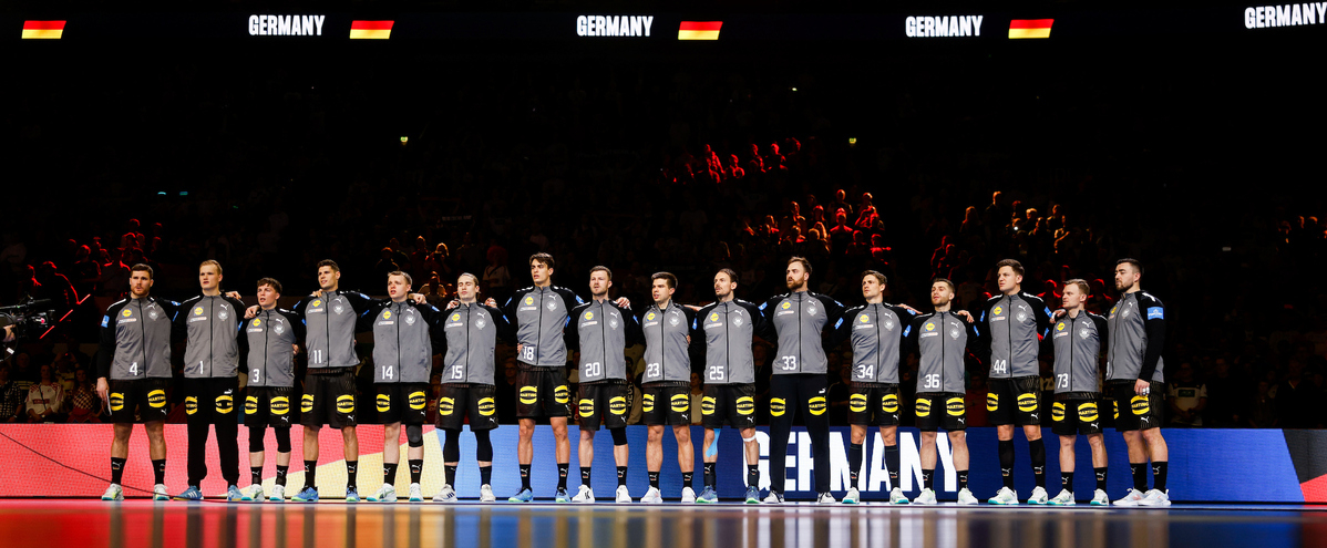 Handballmannschaft in einer Reihe vor dem Anpfiff