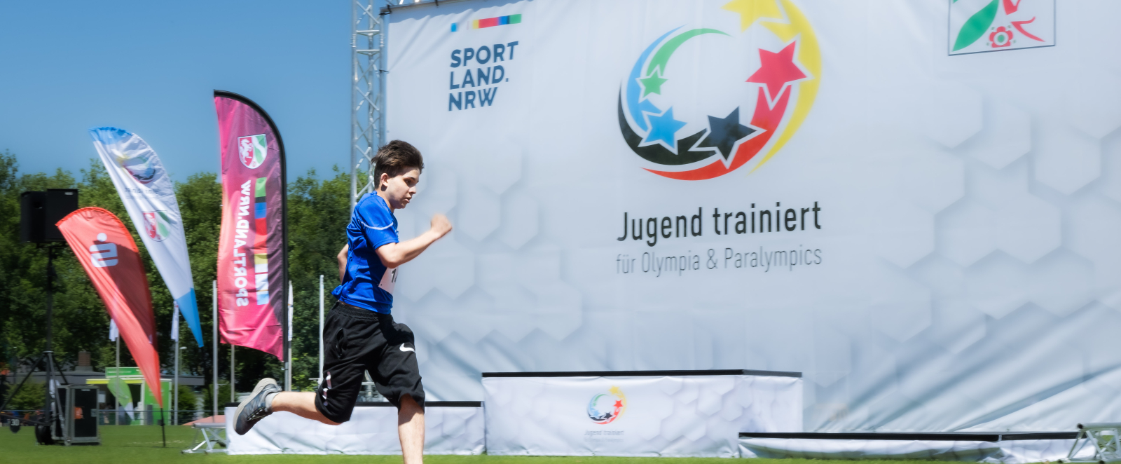 Jugendlicher vor dem Banner von Jugend trainiert