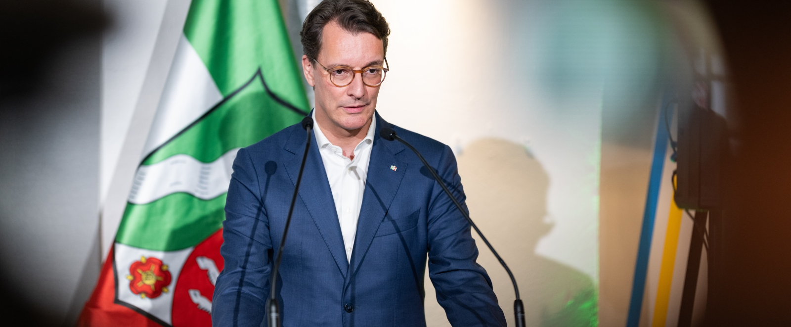Ministerpräsident Wüst an einem Rednerpult mit NRW-Flagge im Hintergrund
