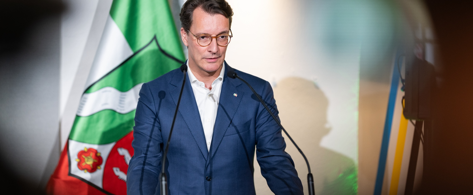 Ministerpräsident Wüst am Rednerpult mit einer NRW-Fahne im Hintergrund