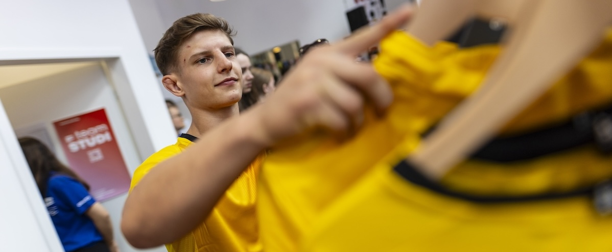 Eine Person hängt ein Oberteil wieder zurück an eine Kleiderstange