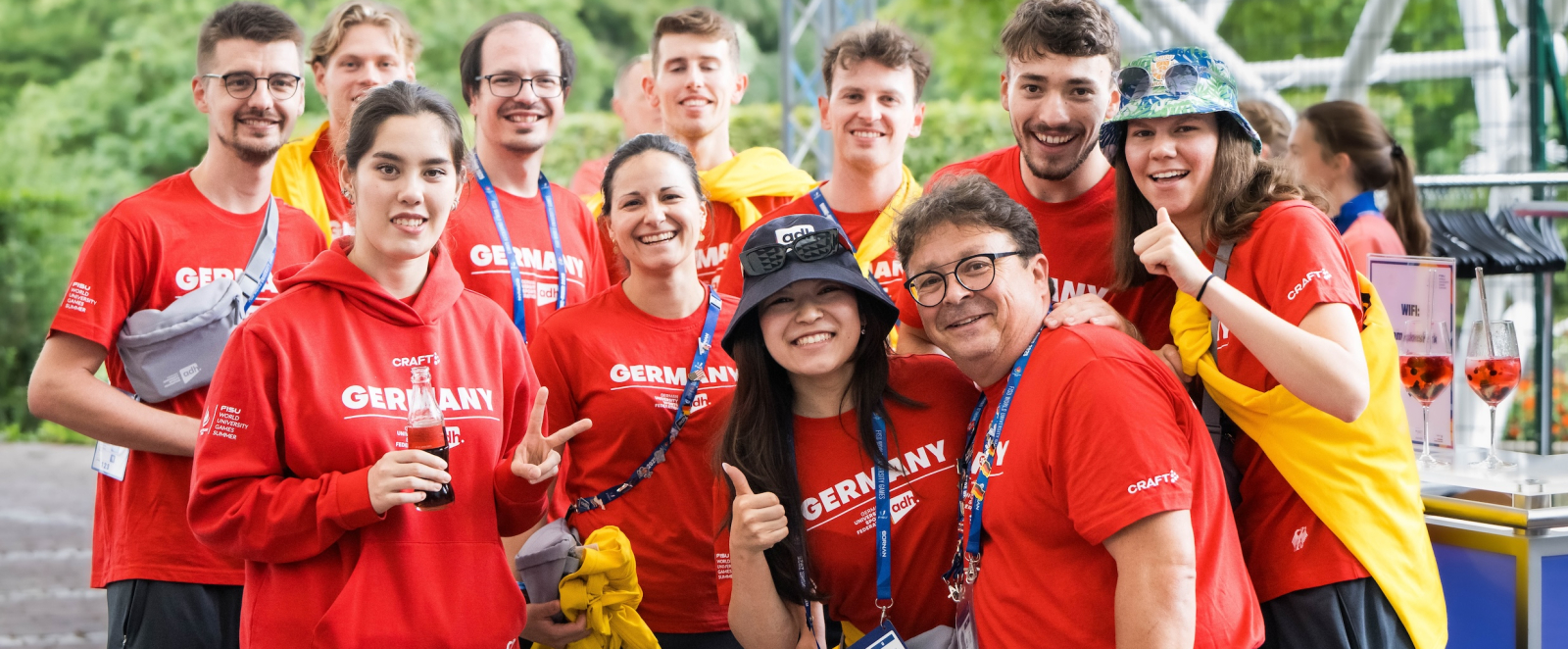 Viele Menschen in roten Shirts und Hoodies mit lächelnden Gesichtern
