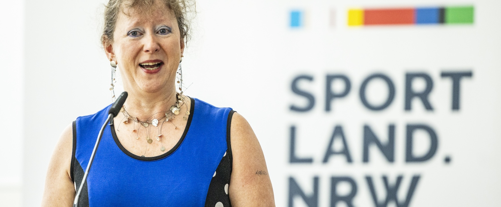Andrea Milz vor Sportland.NRW-Schriftzug