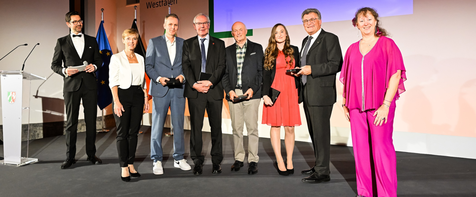 Geehrte bei der Verleihung der Sportplakette auf einer Bühne mit Andrea Milz