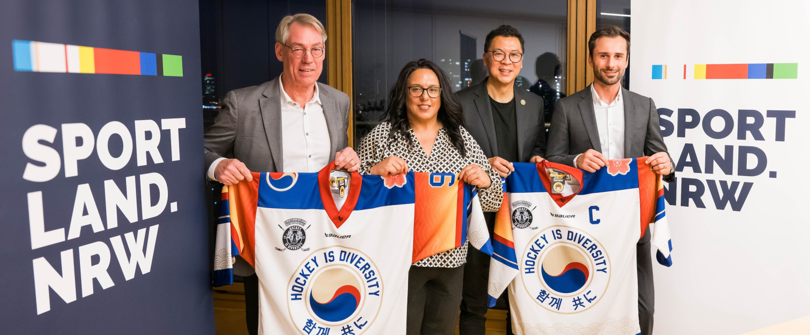 vier Personen mit T-Shirts in der Hand