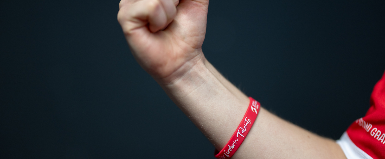 geballte Faust, rotes Band am Handgelenk