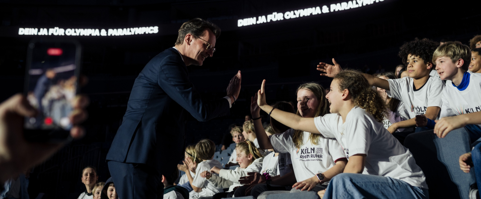Ministerpräsident Wüst klatscht mit Kindern ab