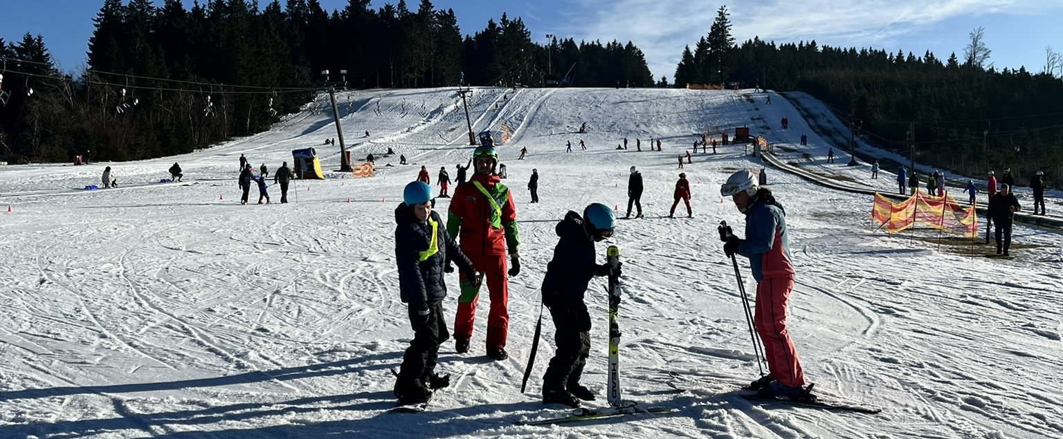 Personen in Skikleidung auf einer Piste