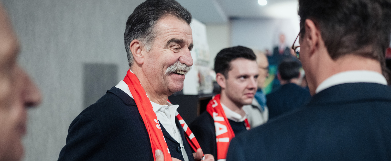 Ministerpräsident Wüst im Gespräch mit einem mann mit Köln-Schal