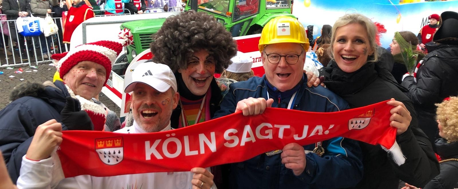 Personen halten ein rotes Banner mit JA für Olympia beim Rosenmontagtszug in Köln
