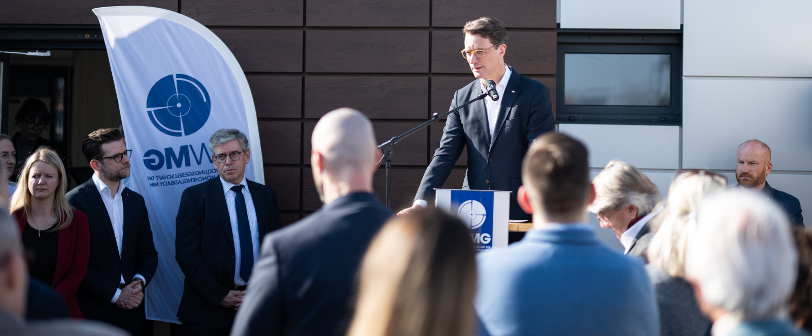 Wüst an einem Rednerpult im Freien beim Spatenstich