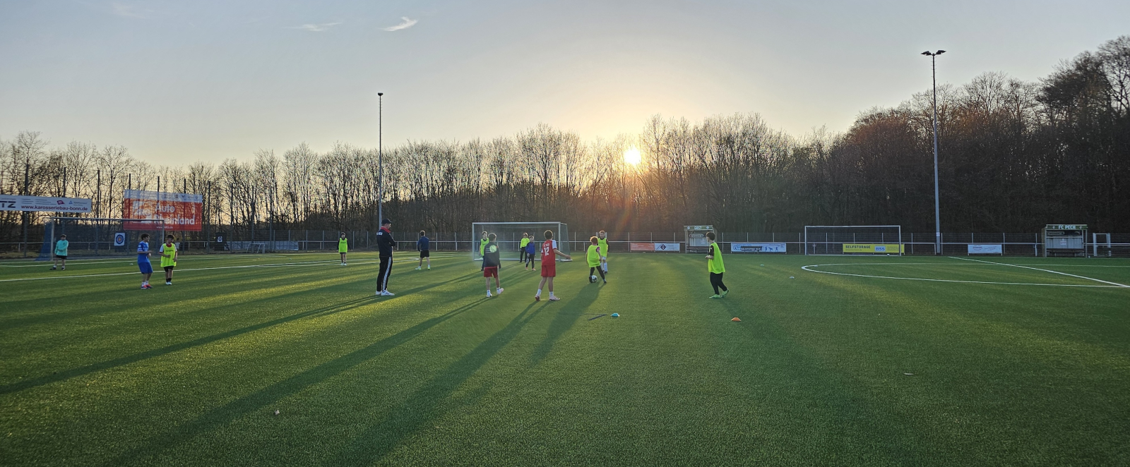 Blick auf einen Sportplatz mit Jugendlichem im Hintergrund