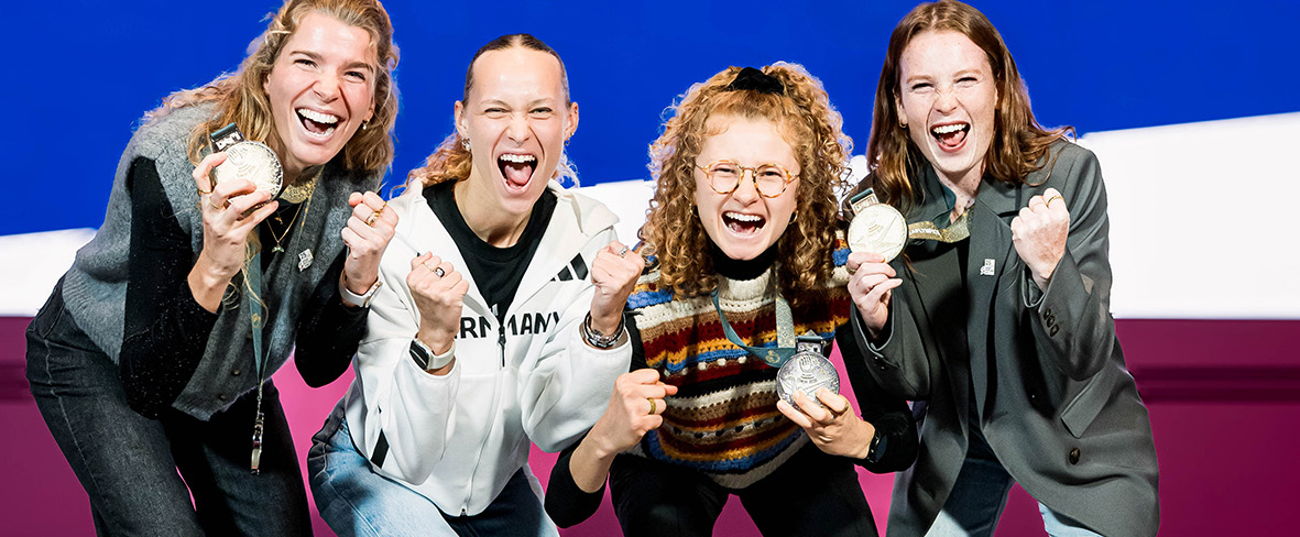 Vier Personen vor einem blauen banner