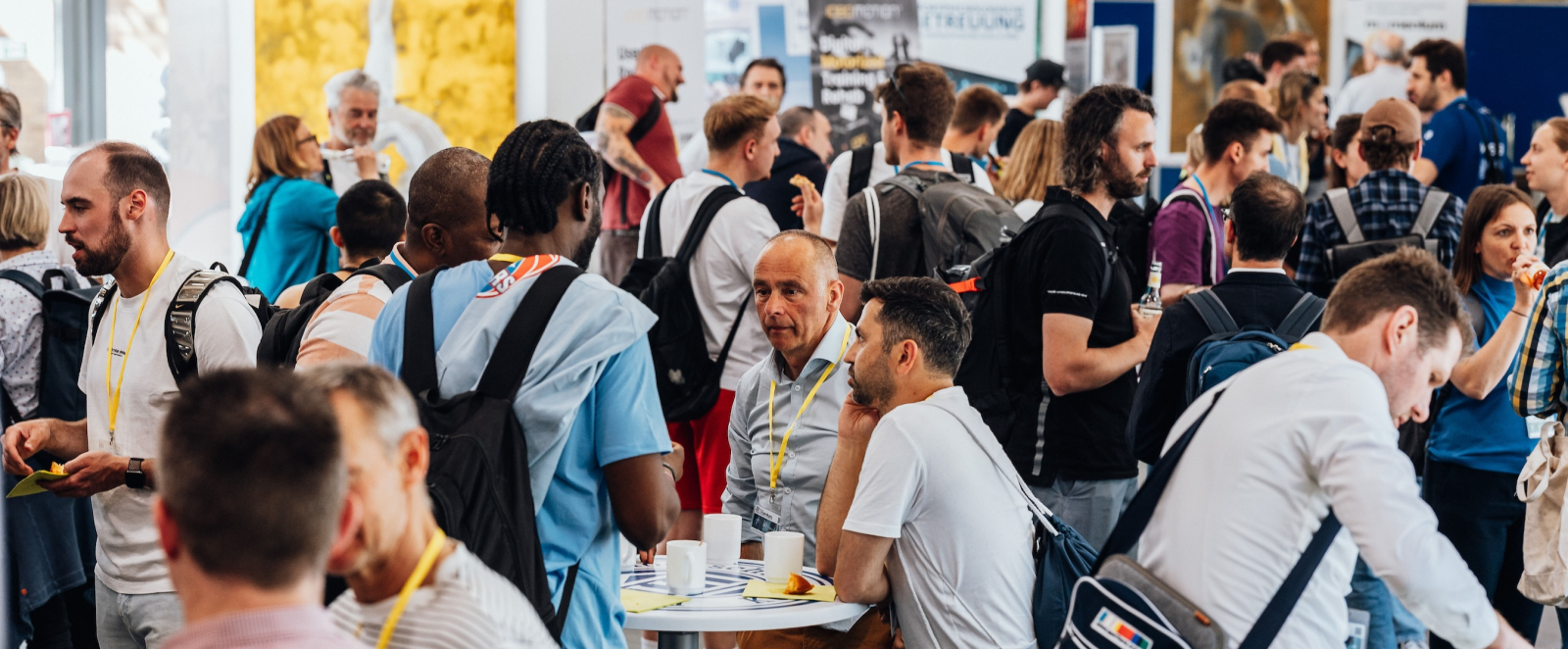 Vielen Menschen an Stehtischen, die sich unterhalten