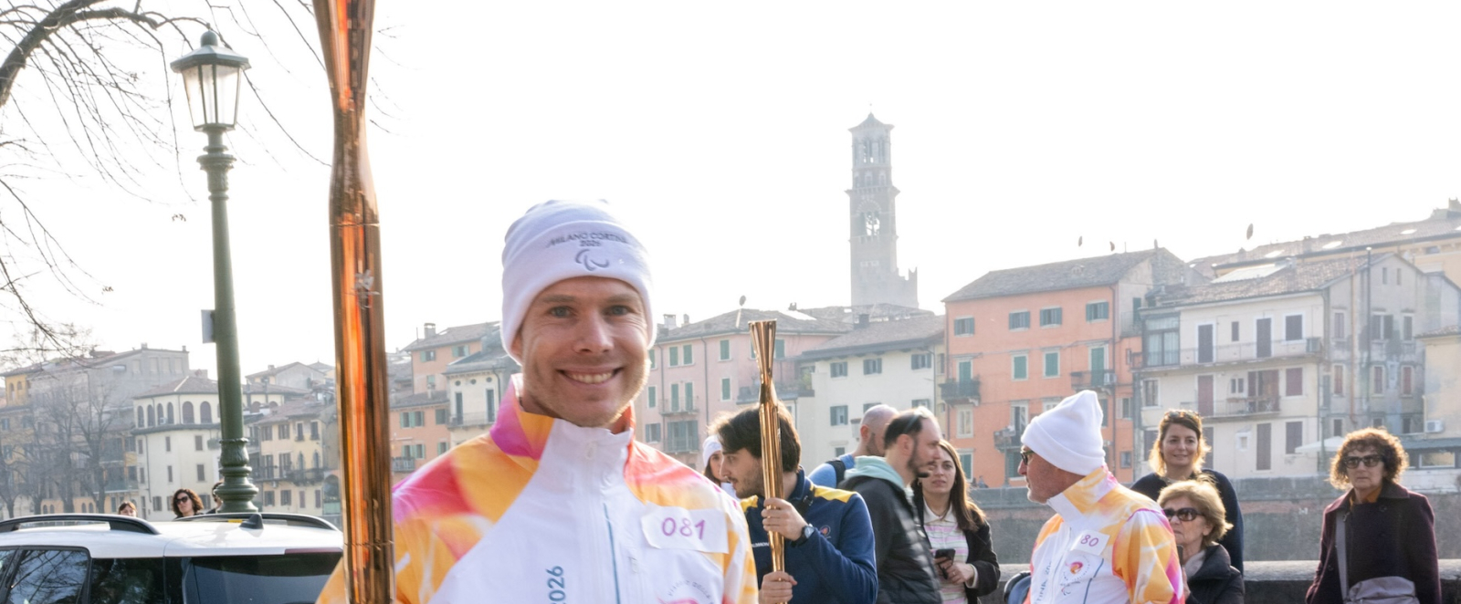 Markus Rehm in heller Kleidung trägt die Paralympics-Fackel 