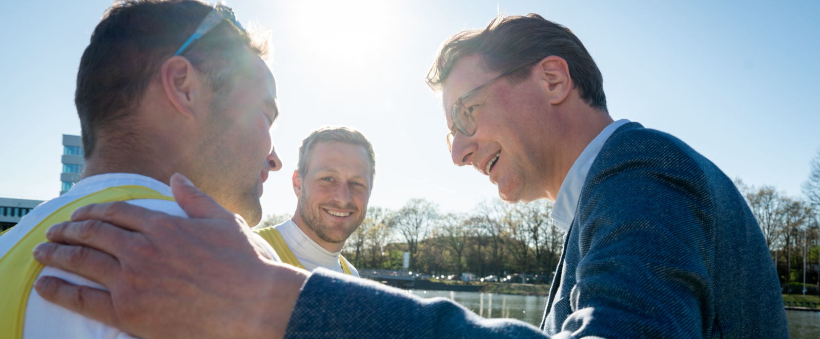 Hendrik Wüst im Gespräch mit zwei Ruderern an der Regattastrecke in Duisburg