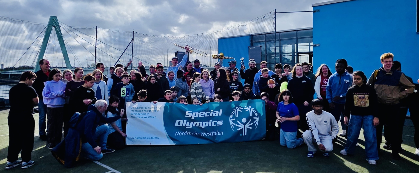 Gruppe von Schülern auf einem Rasefeld vor blaumen Himmel