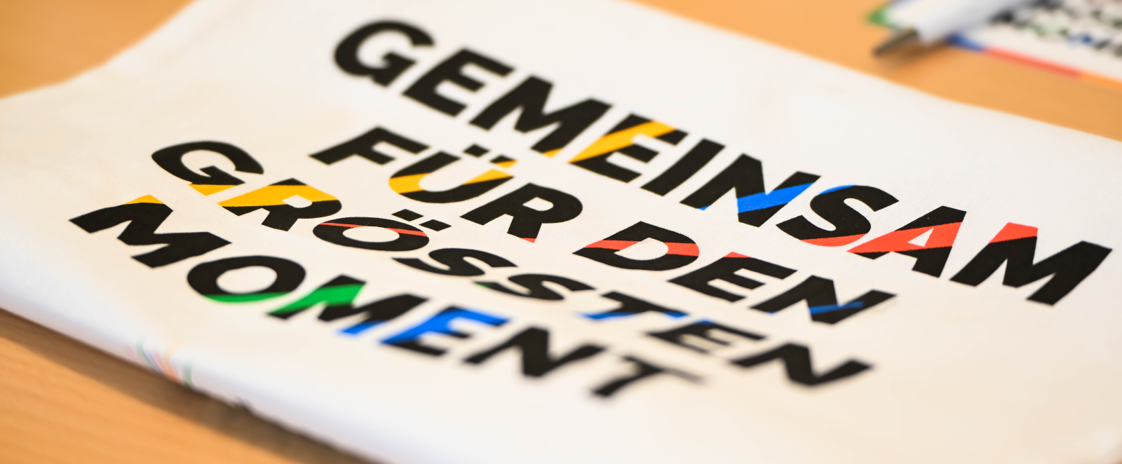Auf einem Tisch liegt ein Zettel "Gemeinsam für den großen Moment"
