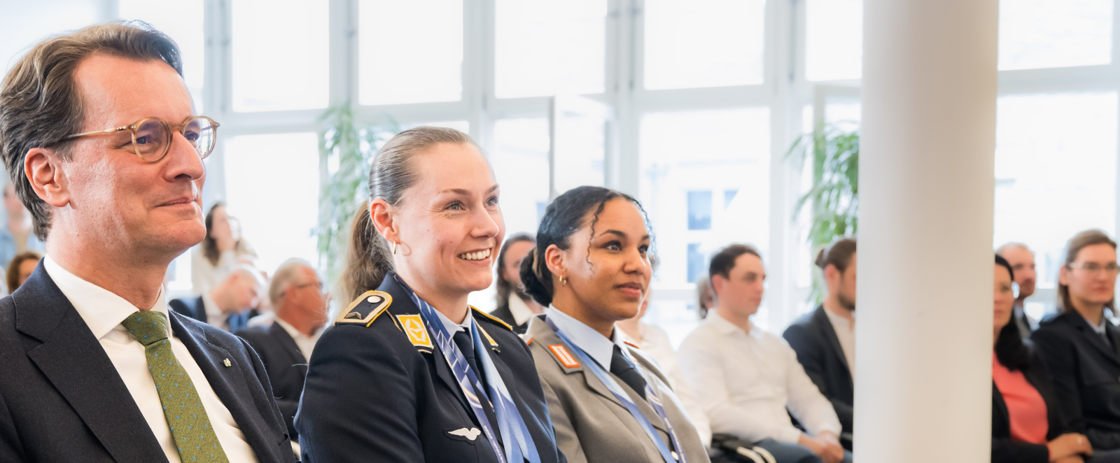 Hendrik Wüst sitzt neben Laura Nolte und Deborah Levi
