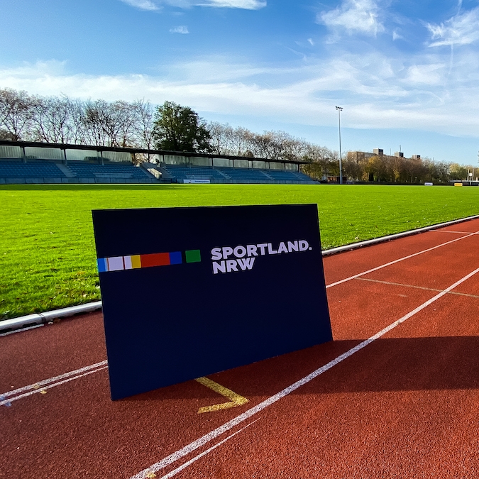 Sportland.NRW-Schild auf Tartanbahn