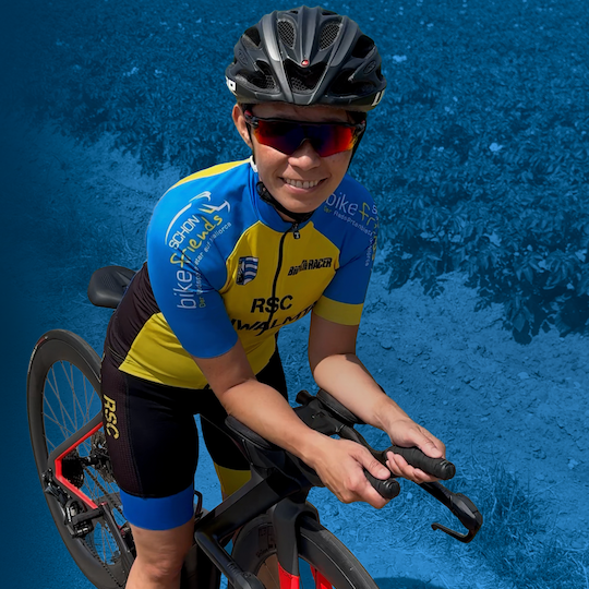 Foto von Vi Scholzen auf dem Rad vor blauem Hintergrund