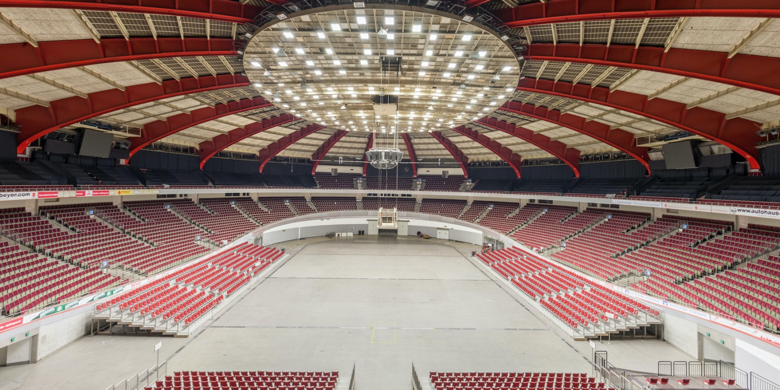Die Westfalenhalle, eine Multifunktionssporthalle in Dortmund aus der Innenansicht, ist innen im Rot-cremefarbenen Farbdesign gestaltet und völlig überdacht.