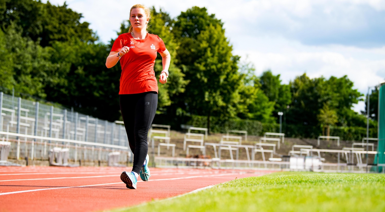 Eine Sportlerin geht über eine rote Tartanbahn