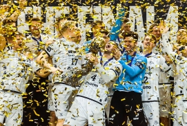 THW Kiel feiern ihren Sieg mit dem EHF Pokal, goldene Lametta regnet von oben herab.