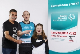 Handball-Legende Heiner Brand sowie die Special Olympics AthletInnen Alexandra Reck und Julian Steffens mit dem Plakat