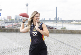 Flag Football-Spielerin in Düsseldorf mit Fernsehturm im Hintergrund