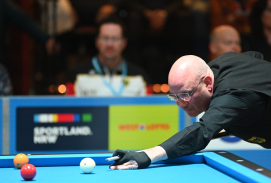 Mann mit Queue spielt Billard