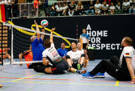 Mehrere Teilnehmende spielen Sitz-Volleyball