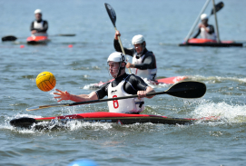 Kanu-Polo-Spieler auf dem Wasser kämpfen um einen gelben Ball