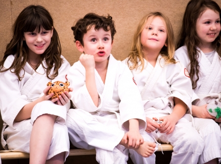 Drei Mädchen und ein Junge in Judo-Bekleidung 